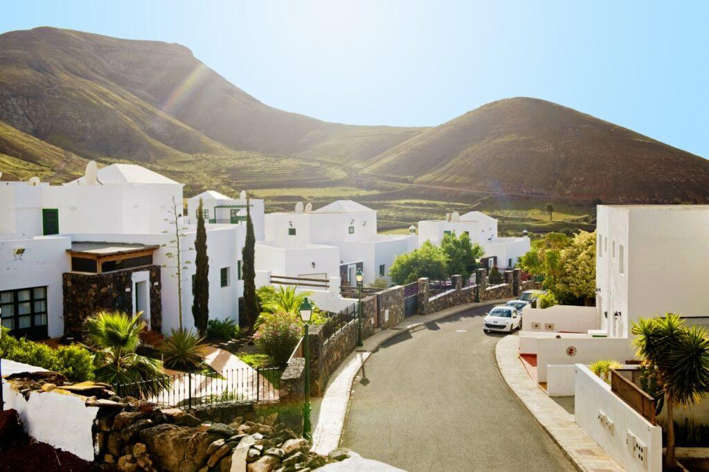 Hvite hus på gate ved bare fjell på Lanzarote