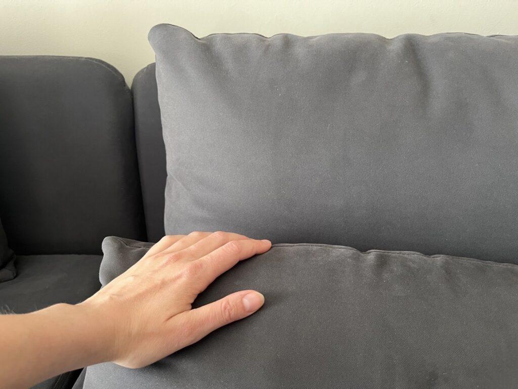 Nærbilde av en grå sofa. Vi forteller deg de grufulle faktaene om hvor skitne sofaen og gulvteppet egentlig er.