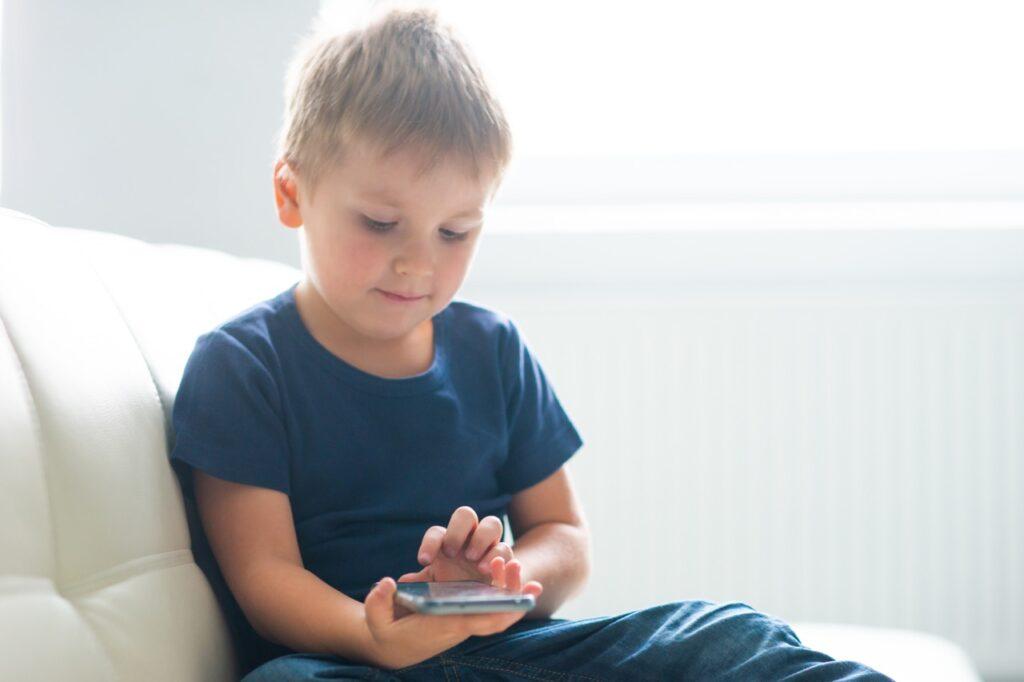 Bilde av barn som holder en mobil. Vi har funnet frem mobilabonnementene som er best og billigst til barn fra Telia, Ice og PlussMobil. 