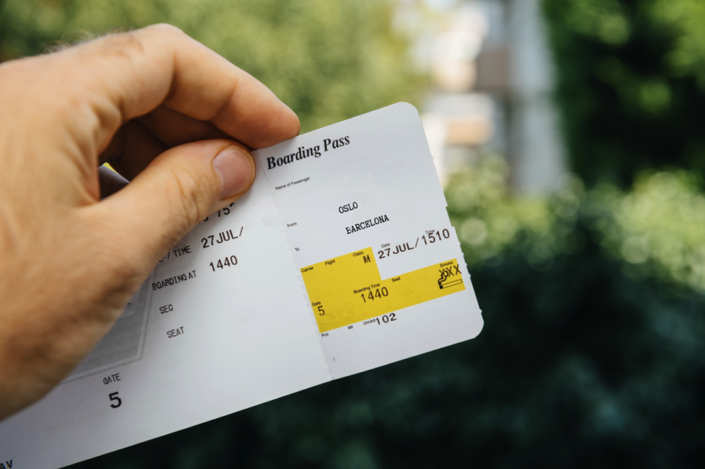 Bilde av hand som holder en flybillett merket fra Oslo til Kreta. Vi forteller hvordan du kan sikre deg billigst mulige flybilletter ved å fortelle hvilken dag det er billigst å bestille flybilletter og når på dagen det er billigste flypriser.