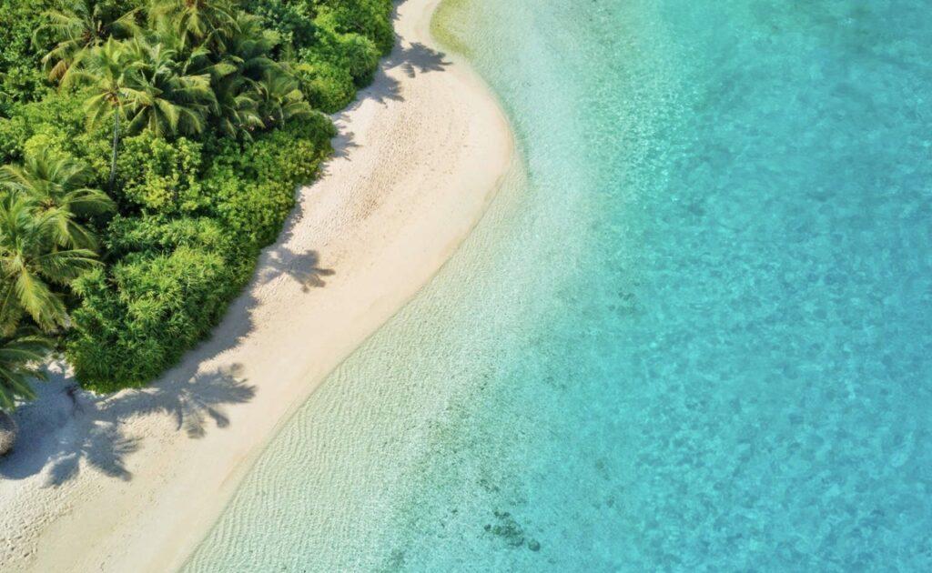 Bilde av azurblått hav og hvite strender med palmer på Maldivene. Til tross for høyere renter, dyrere mat, høye strømpriser og generelt høyere utgifter i 2023 har det dukket opp en luksuriøs reisetrend for dyrere og mer eksotiske reiser. Vi forteller hvor folk bestiller seg reiser i år.