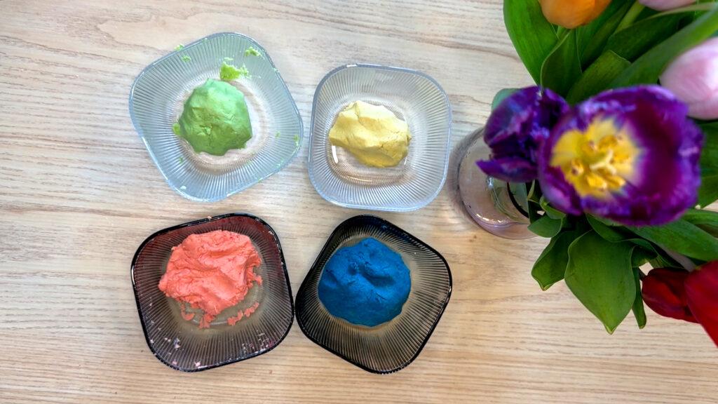 Fire ulike lekedeigeri hver sin glassskål, blå, gul, rosa og grønn. Her viser vi oppskriften på lekedeig med to ingredienser.