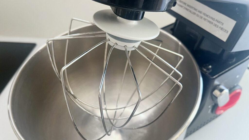 Bilde av svart kjøkkenmaskin med en visp som står på en kjøkkenbenk, til saken vår som avslører hvilke kjøkkenmaskiner fra merker som KitchenAid, Bosch, Ankarsrum, Kenwood og Cuisinart som er best i test i 2023.