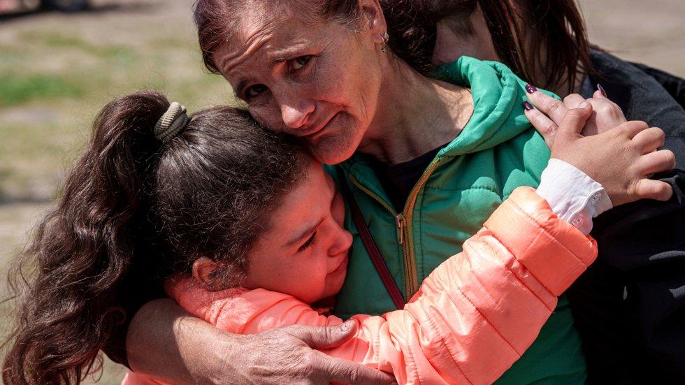 2024 年 5 月 12 日星期日，撤离乌克兰沃夫昌斯克后，Khrystyna Pyimak（11 岁）拥抱母亲 Oksana Velychko。俄罗斯空袭该镇后，她的丈夫在家中丧生。照片：美联社/Evgeniy Maloletka