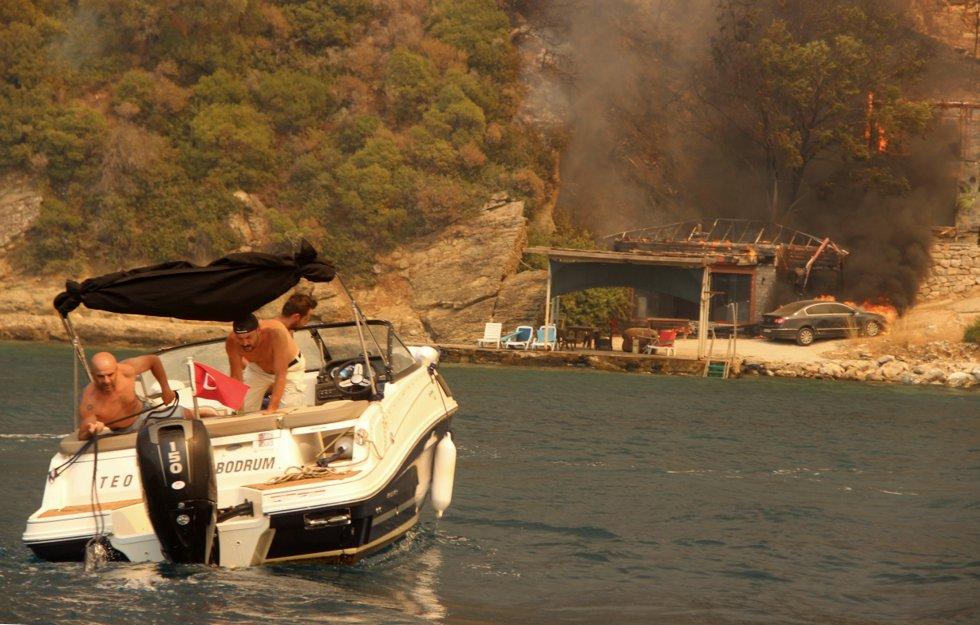 The summer paradise along the coast near Bodrum in Turkey has become a fire inferno where people desperately fled from the flames in holiday boats on Sunday.  Photo: IHA via AP / NTB Photo: AP