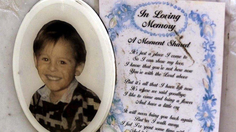 C'è un biglietto dietro la foto del bambino James Bulger assassinato sulla sua tomba nel cimitero di Kirkdale a Liverpool il 22 giugno 2001. Fotografia: Ian Hodgson/Reuters/NTB