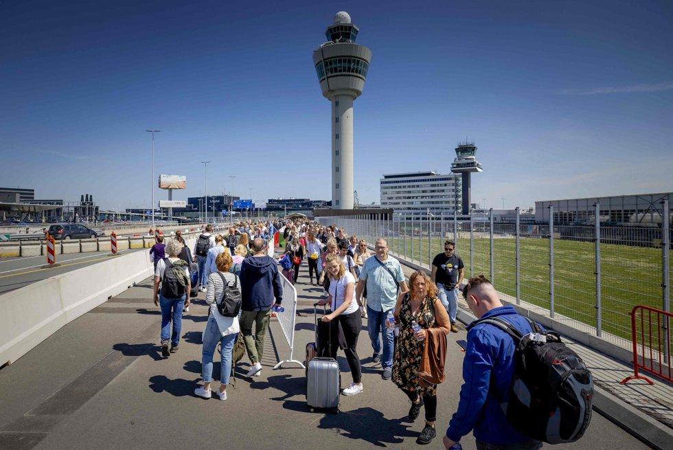 Voor reizigers die op Schiphol buiten Amsterdam moesten inchecken, begon vrijdag de wachtrij buiten het terminalgebouw.  Passagiers kregen de opdracht om vier uur voor vertrek aan te komen.  Foto: Robin von Lonquisen / AFP